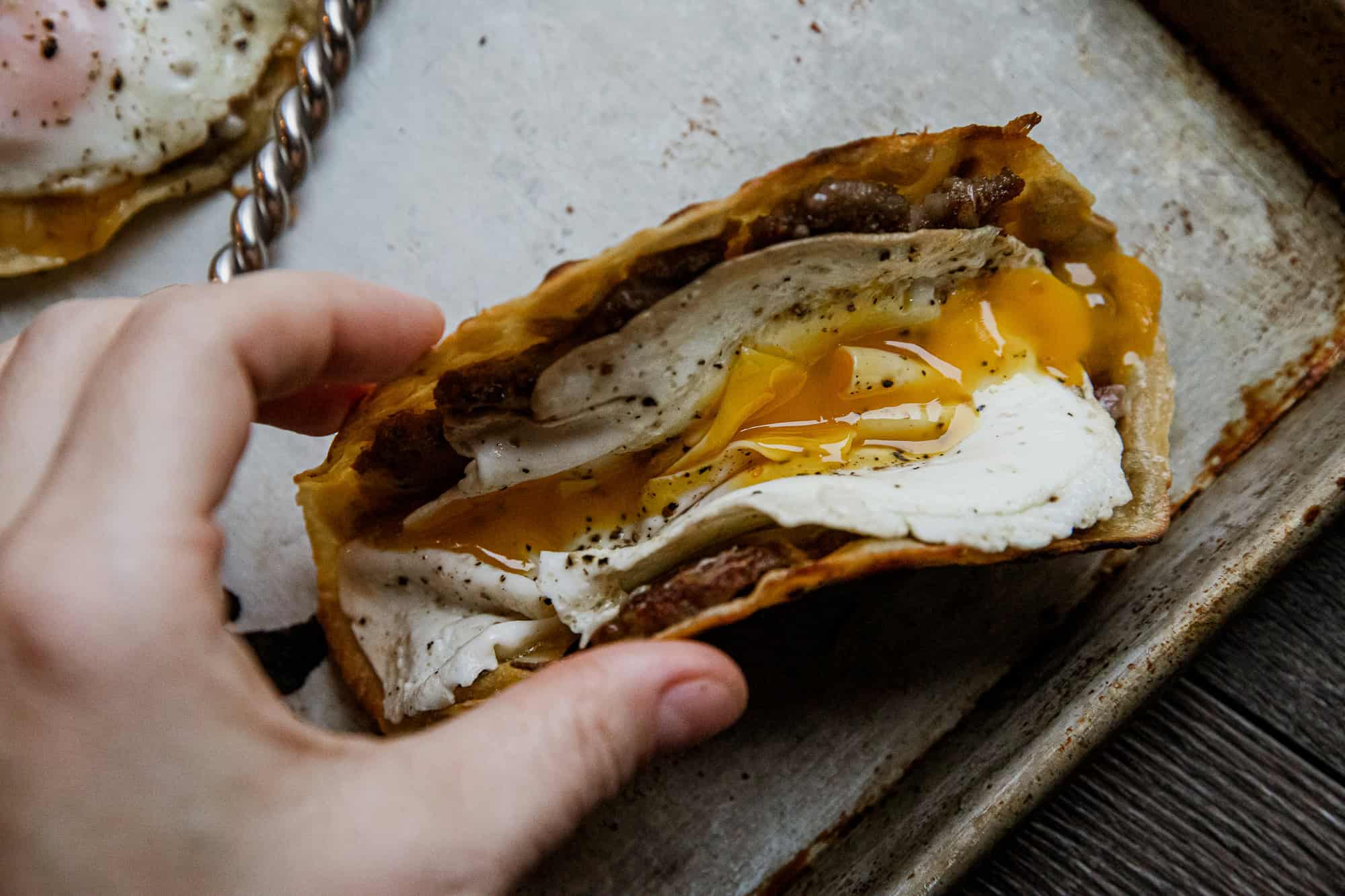 Delicious breakfast tacos with eggs, sausage, and cheese on a crispy tortilla. Perfect for a hearty.